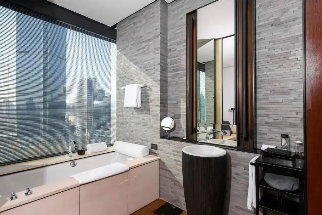 Modernes Badezimmer mit Stadtblick und hochwertigen Armaturen.
