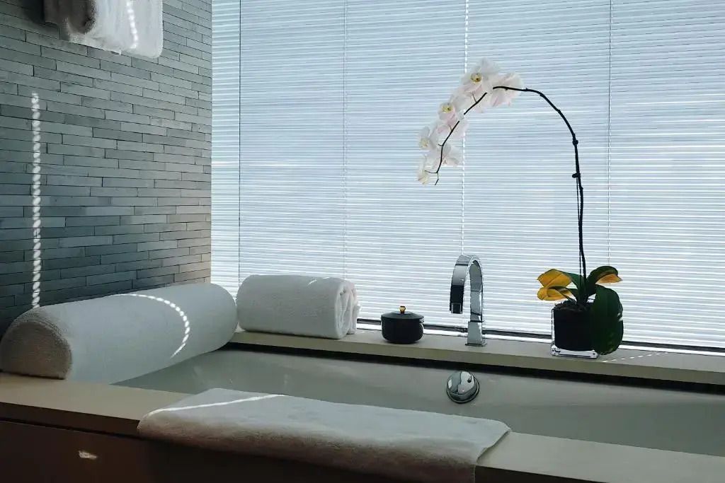 Badewanne mit Orchidee und natürlichem Licht.