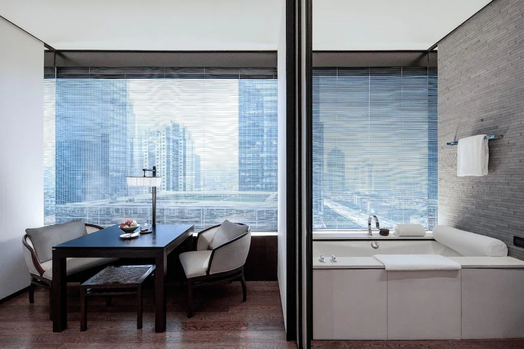 Eleganter Sitzbereich im Deluxe Doppelzimmer mit Blick auf die beeindruckende Skyline.