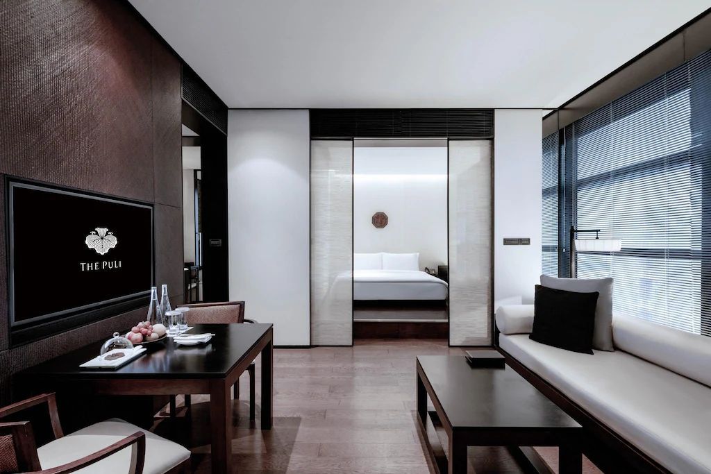 Gemütliche Suite mit Esstisch und Sofa in der Junior-Suite des Puli Hotels