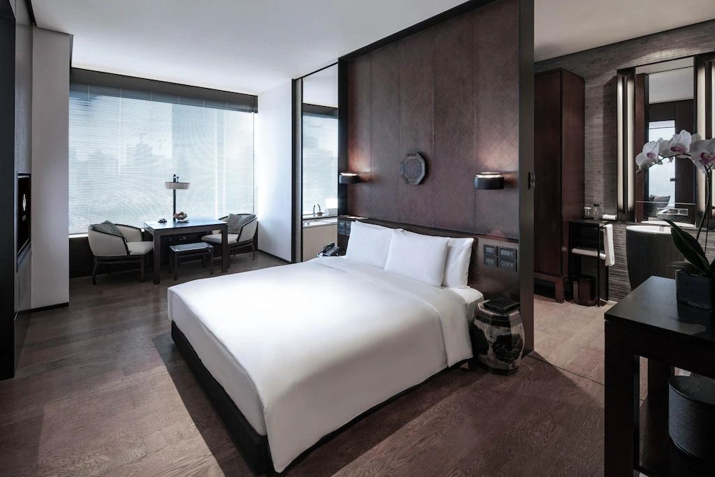 Modernes Hotelzimmer mit Doppelbett und Stadtblick im Hintergrund