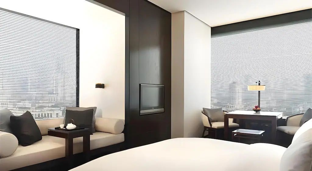 Gemütlicher Sitzbereich und Bett in einem modernen Hotelzimmer