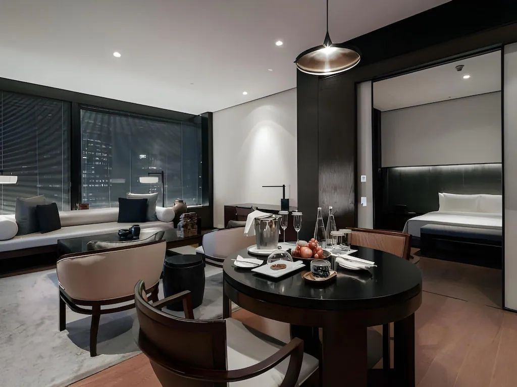 Eleganter Wohnbereich der Jing'An Suite mit Esstisch, Sitzbereich und Stadtblick.