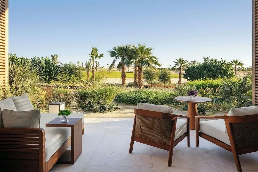 Terrasse mit Sitzgelegenheit und Blick auf eine üppige Gartenlandschaft
