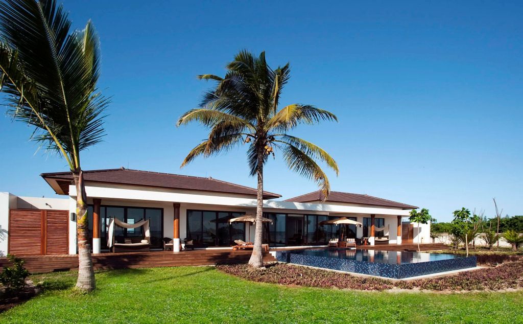 Weitläufiges Anwesen der Präsidenten Pool Villa mit grüner Wiese und Palmen