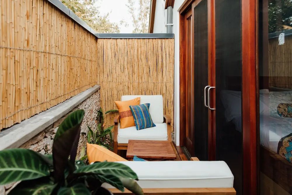 Private Terrasse mit gemütlichen Sitzmöbeln und Bambuswand im Deluxe Zimmer