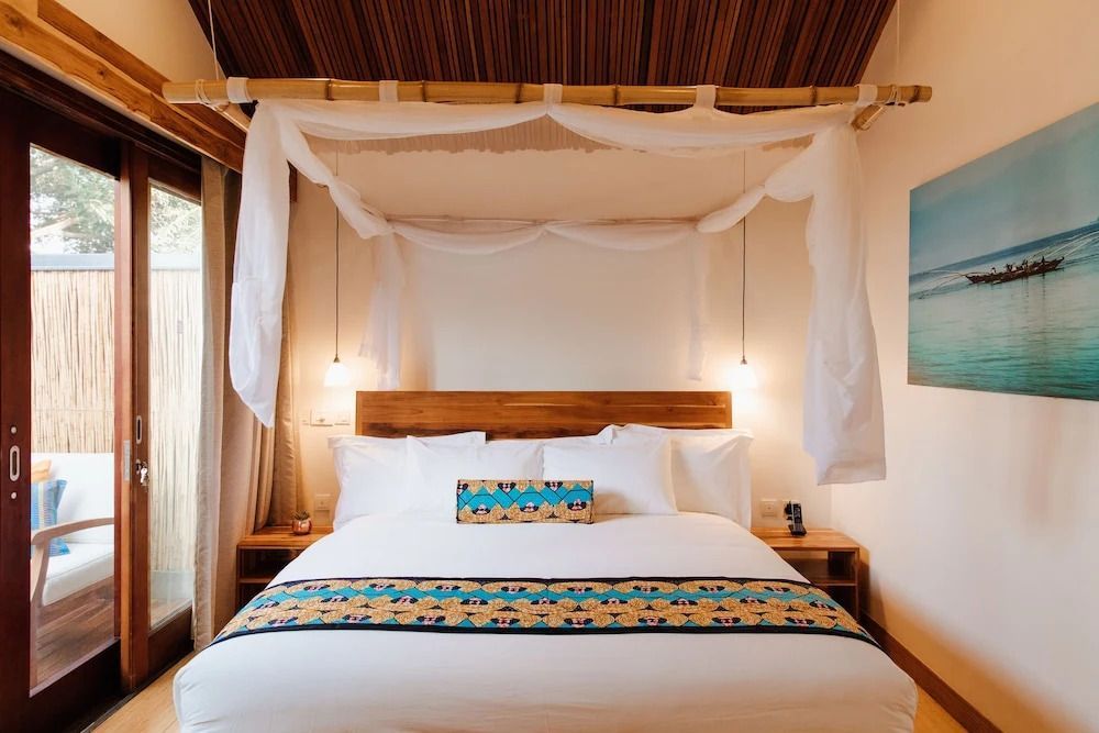 Luxuriöses Doppelbett mit Baldachin und eleganten Kissen im Deluxe Zimmer