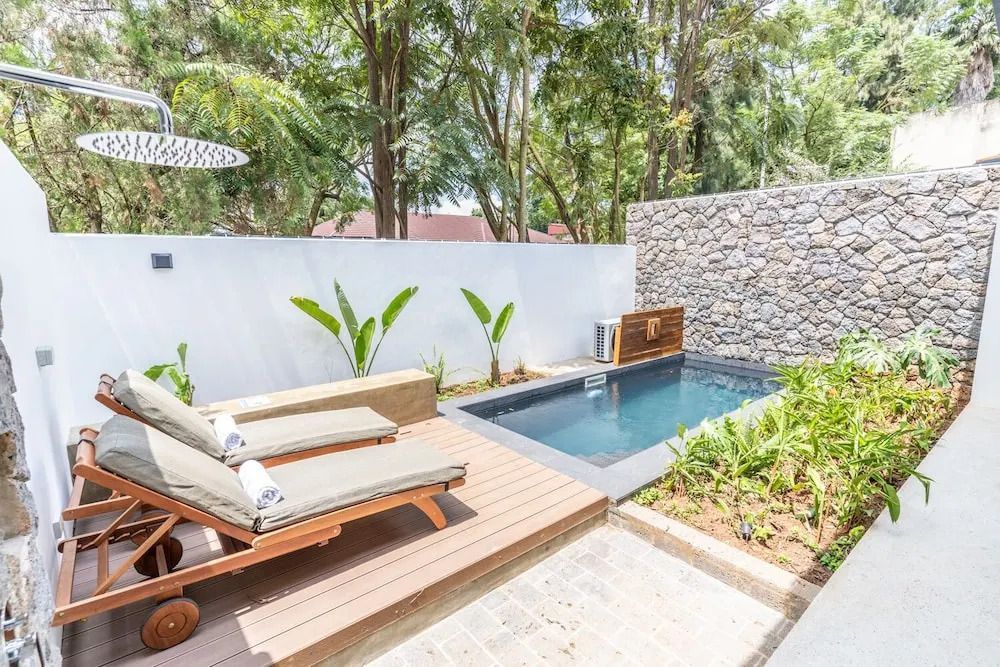 Privater Pool mit Liegestühlen und grüner Gartenumgebung