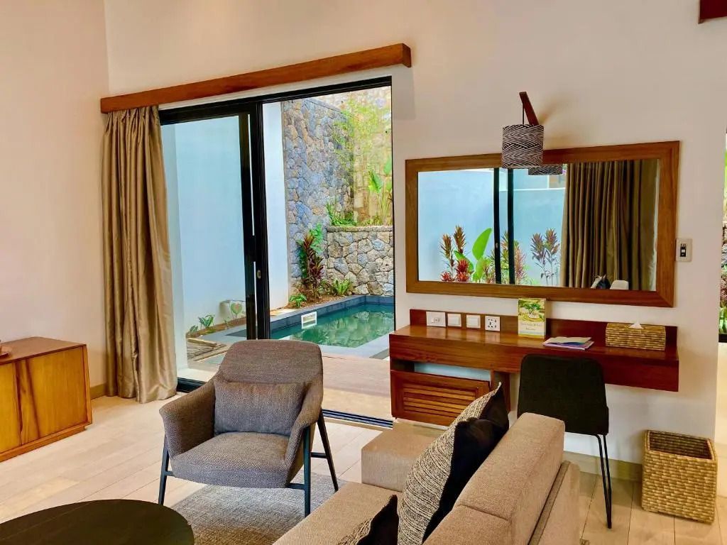 Elegantes Wohnzimmer einer Villa mit Blick auf den privaten Pool und moderner Einrichtung