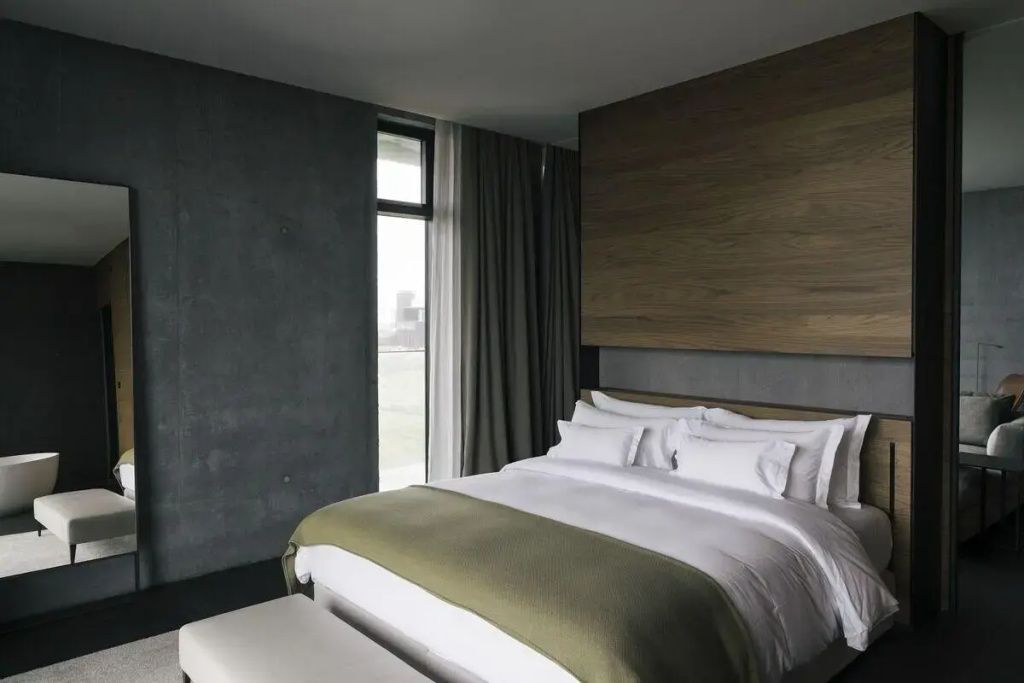 Elegantes Schlafzimmer einer Suite im The Retreat at Blue Lagoon mit Holzverkleidung und Ausblick.