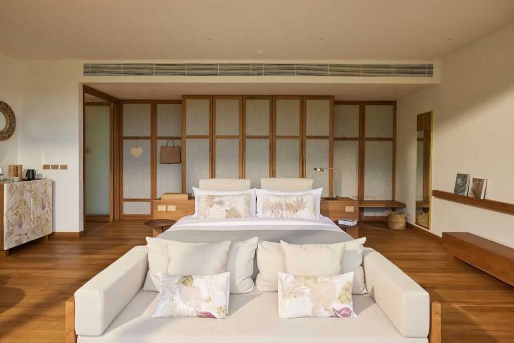 Großes Doppelbett mit eleganten Kissen und Holzdetails im Zimmer