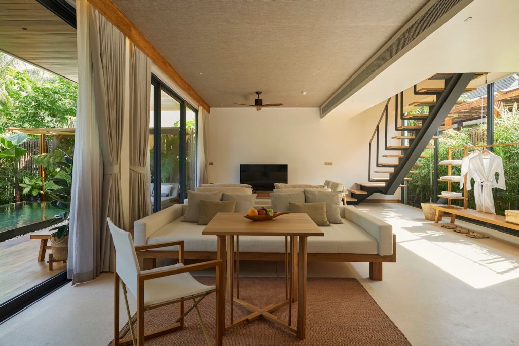 Geräumiges Wohnzimmer mit Treppe und modernen Sitzmöglichkeiten