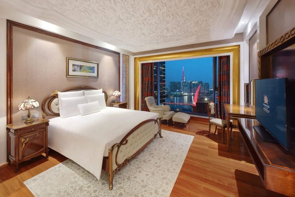 Luxuriöses Schlafzimmer im The Reverie Saigon mit Panoramafenster und Stadtblick