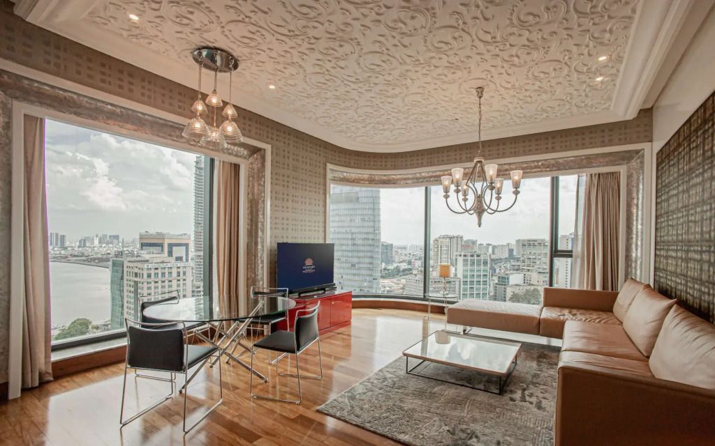 Stilvoll eingerichtetes Wohnzimmer mit großem Fenster und Stadtblick im The Reverie Saigon