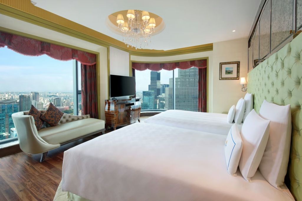 Geräumiges Zimmer mit zwei Einzelbetten und einem Panoramablick auf die Stadt.