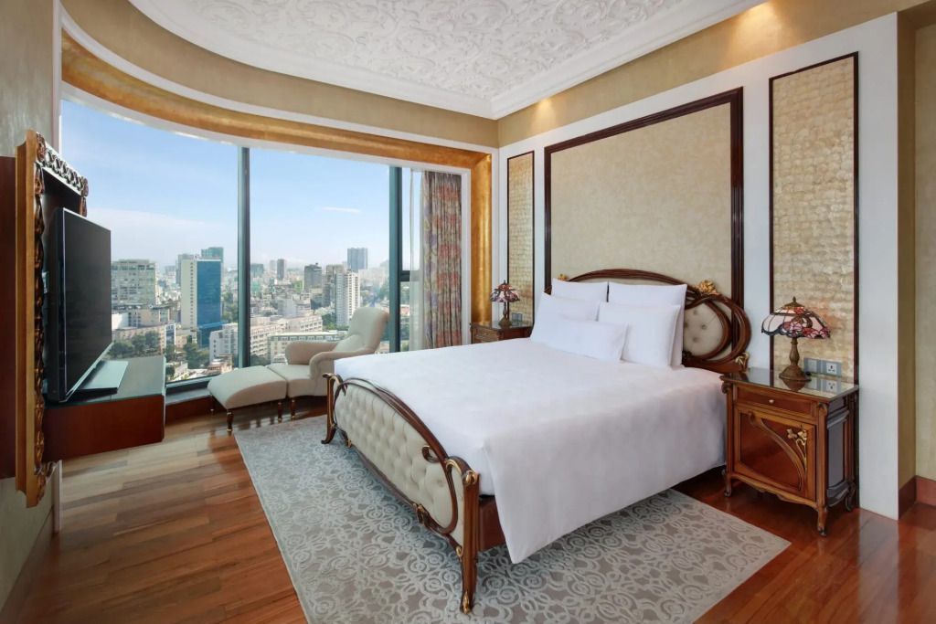 Elegantes Schlafzimmer mit Stadtblick und klassischem Bett.
