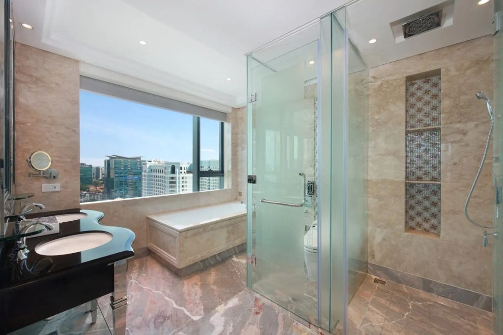 Luxuriöses Badezimmer mit Glasduschkabine und Stadtblick.