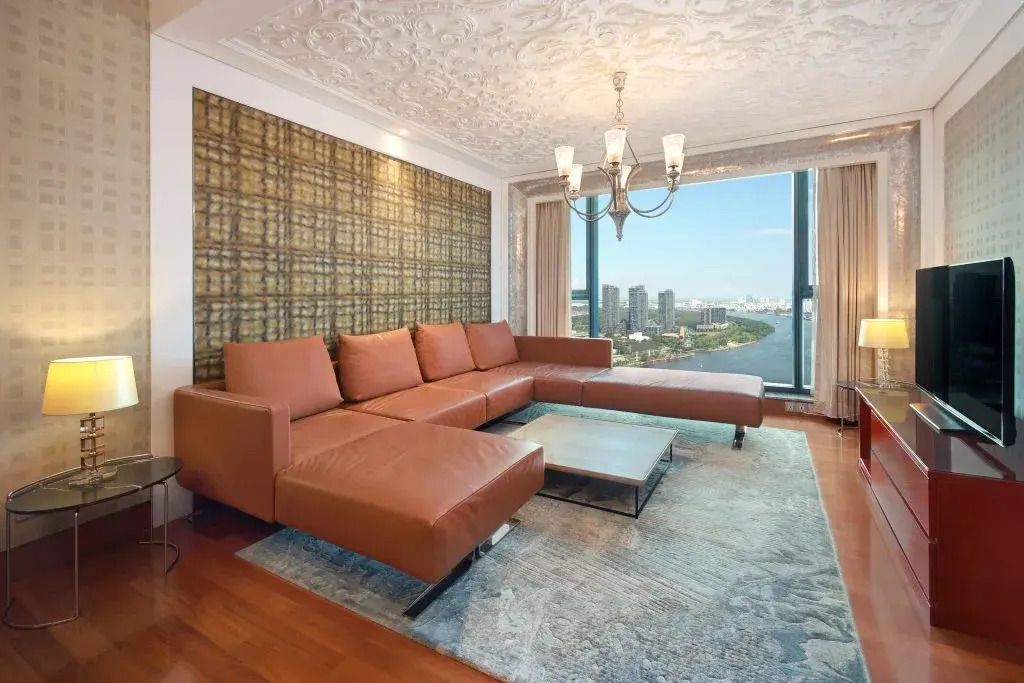 Gemütlicher Wohnbereich mit großer Couch und Blick auf die Stadt.