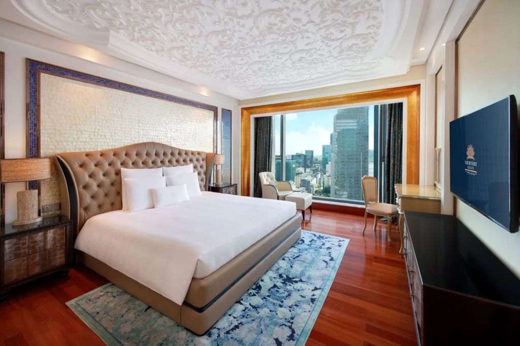 Luxuriöses Schlafzimmer mit großem Fenster und Stadtblick, elegant eingerichtet.