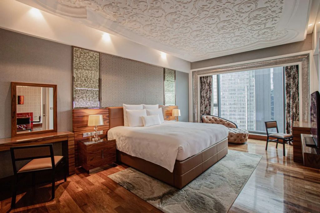 Komfortables Schlafzimmer mit üppigem Dekor und Blick auf die Stadt.