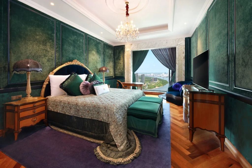Geräumige Suite mit großem Bett, Kronleuchter und Panoramablick auf die Stadt.