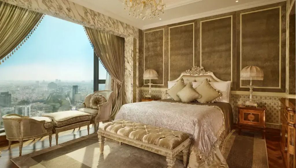 Luxuriöse Suite mit goldenen Akzenten und Panoramafenster mit Stadtblick.
