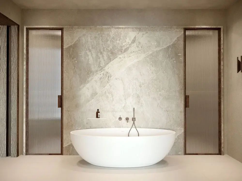 Elegantes Badezimmer mit freistehender Badewanne und Marmor-Wänden.