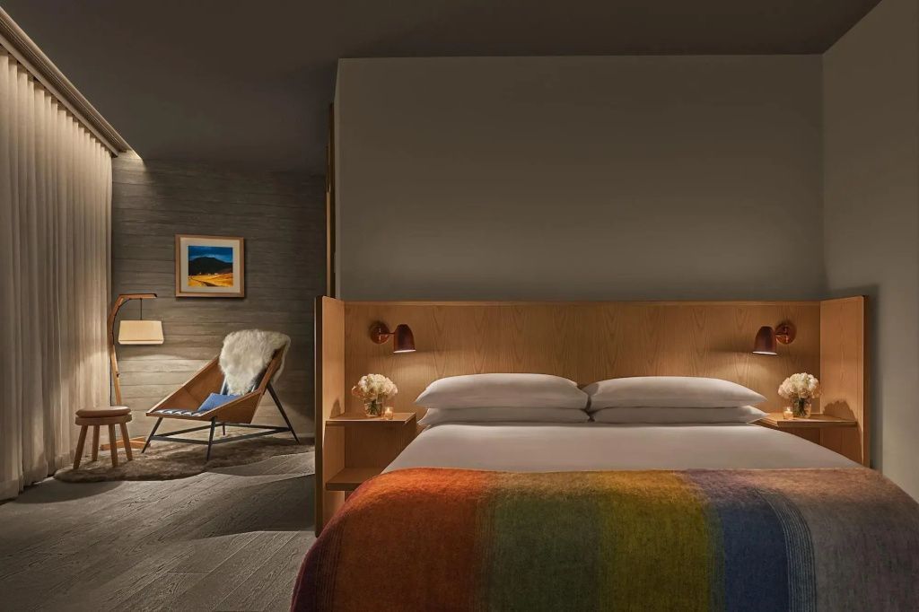 Luxuriöses Schlafzimmer im The Reykjavik Edition mit feiner Bettwäsche und Holzelementen.