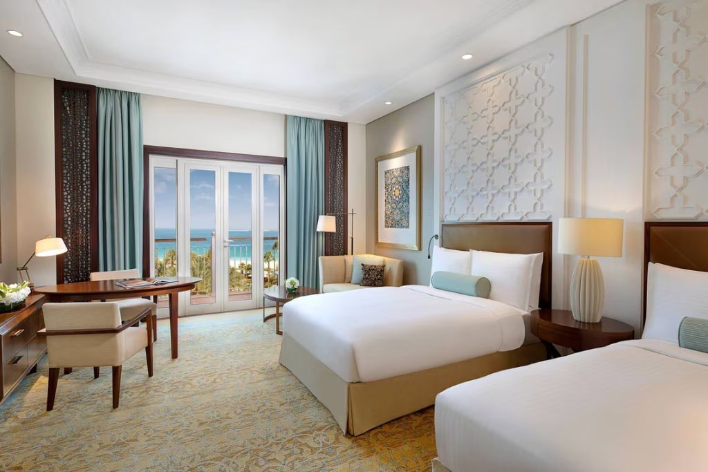 Zimmer mit zwei Betten, stilvollem Interieur und direktem Blick auf das Meer.