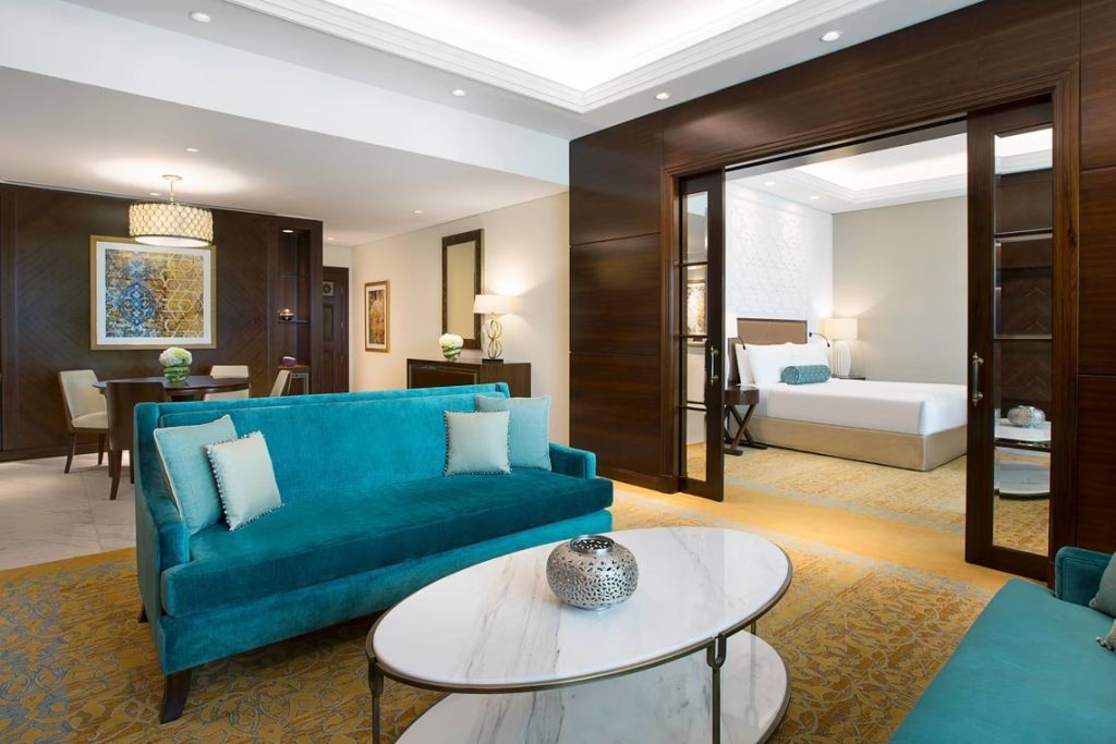 Offener Wohnbereich der Suite in modernen Blau- und Holztönen.