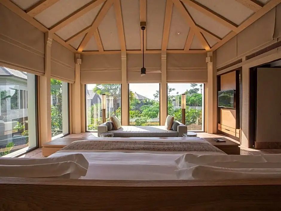 Geräumige Villa mit Panoramafenstern und Gartenblick, modernem Interieur und Doppelbett.