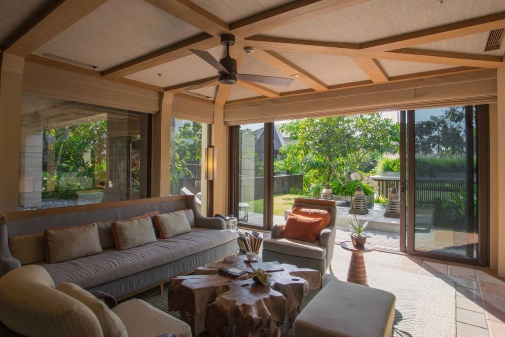 Geräumiger Wohnbereich mit bequemen Sofas und Gartenblick durch große Fenster.