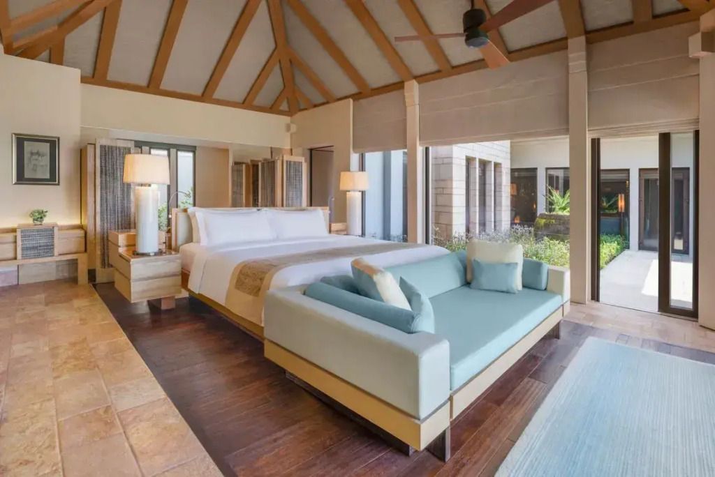 Elegantes Schlafzimmer mit Doppelbett, Holzbalkendecke und modernem Design.