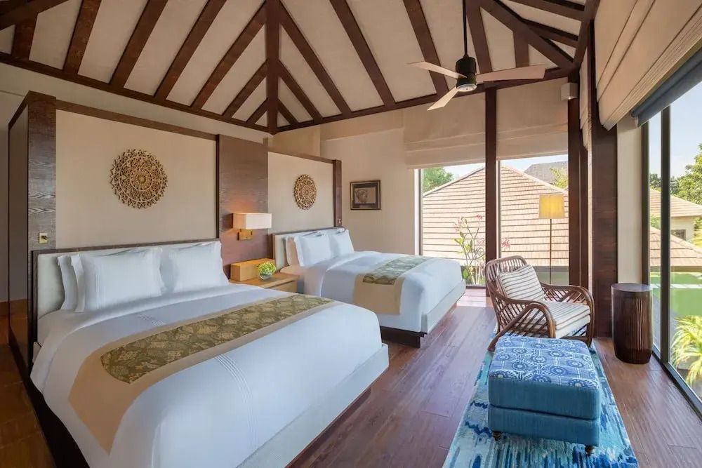 Luxuriöses Schlafzimmer in einer Oceanfront Villa mit zwei Doppelbetten und Holzbalkendecke