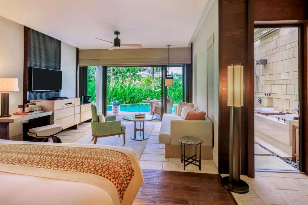 Luxuriöse Suite mit Doppelbett und Blick auf privaten Pool und Garten.
