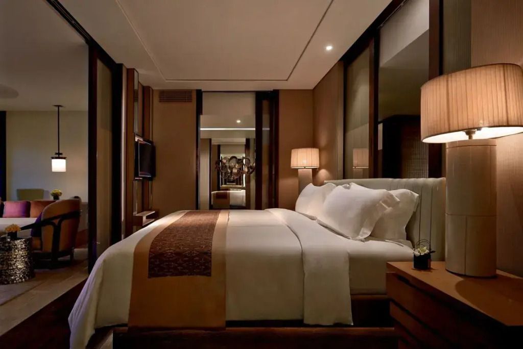 Luxuriöse Suite mit Doppelbett und eleganter Beleuchtung in warmen Tönen
