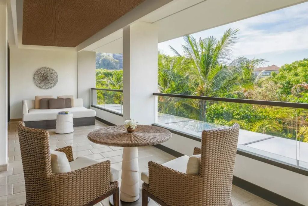 Balkon der Suite mit Blick auf üppige tropische Vegetation und stilvollen Möbeln
