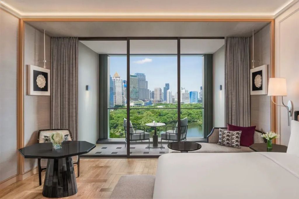 Geräumiges Zimmer mit Blick auf den Lumpini Park und Bangkoks moderne Skyline.