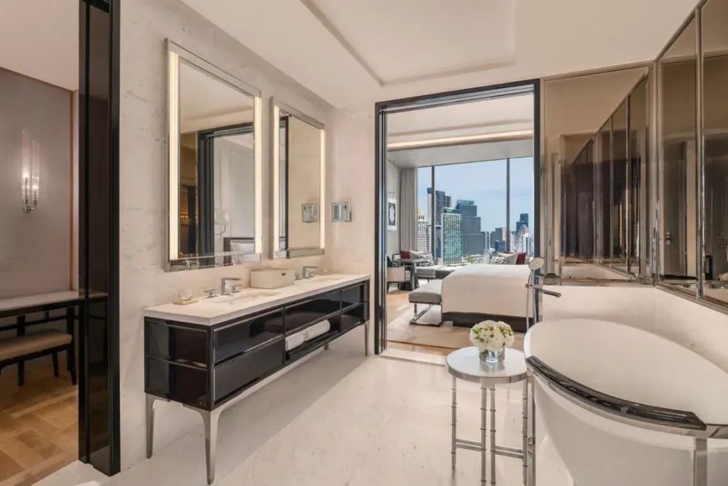Elegantes Badezimmer mit Doppelwaschbecken und Aussicht auf die Stadt in der Gardenia Suite.