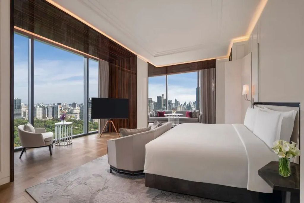 Helles Schlafzimmer mit weiten Fenstern und Ausblick auf Lumpini Park in Bangkok