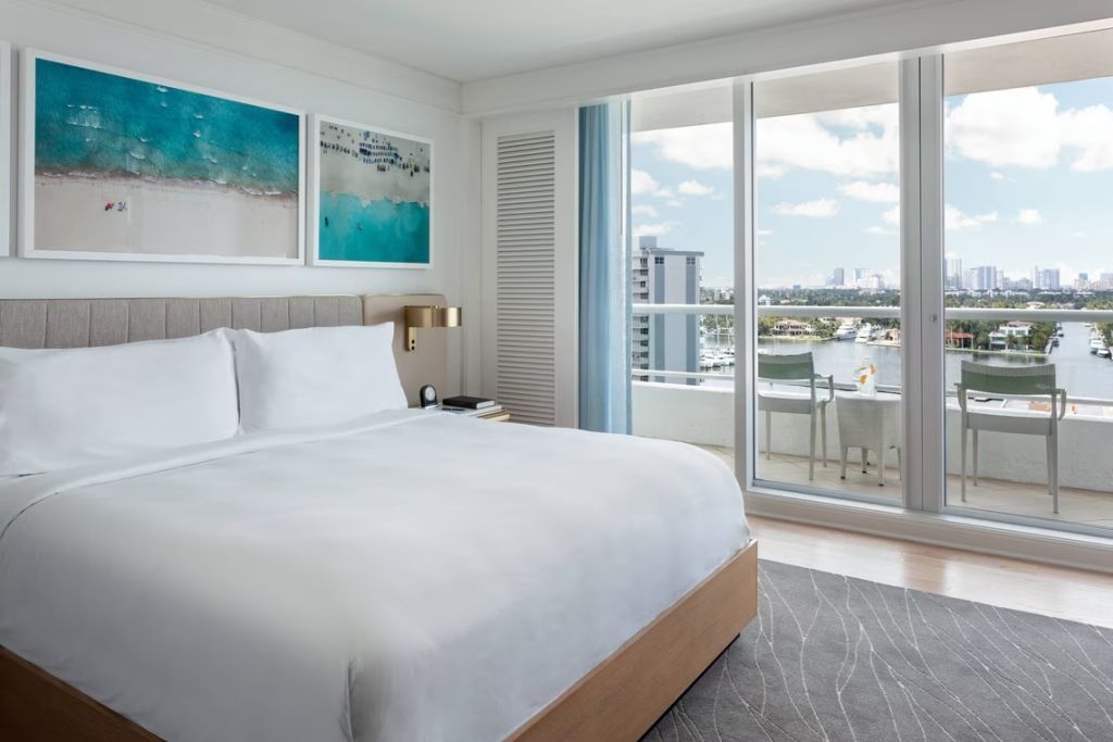 Helles Schlafzimmer mit einem großen Bett und Balkonblick auf den Intracoastal Waterway.