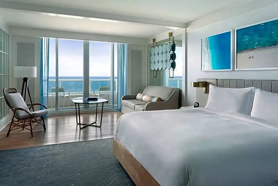 Suite mit Doppelbett, Sofa und Glasfront mit Meerblick