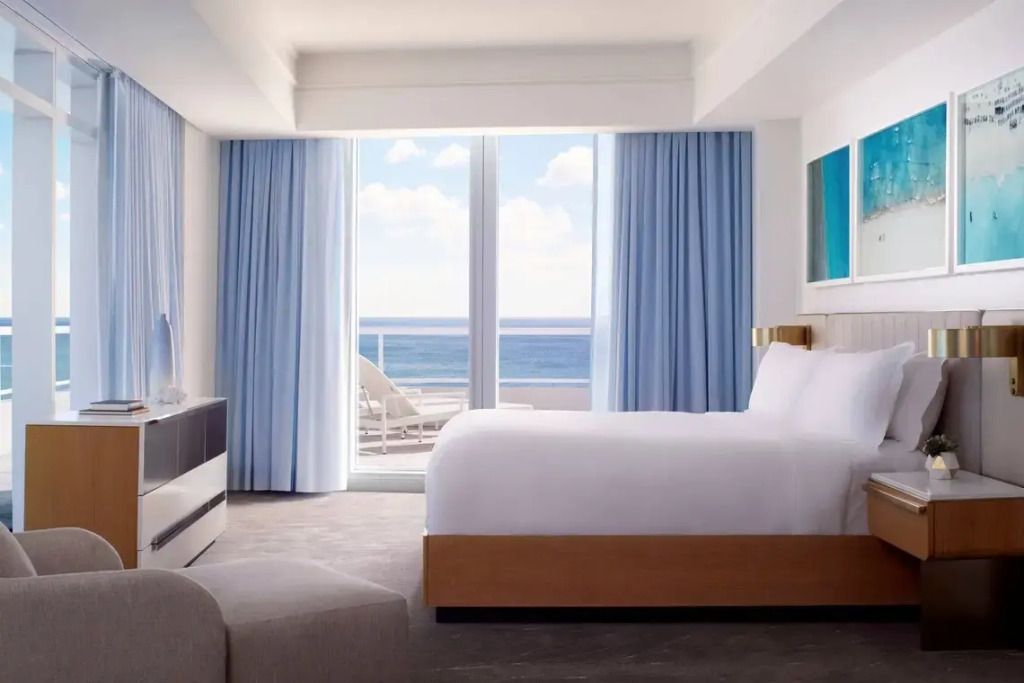 Helles Schlafzimmer mit Blick auf den Ozean durch große Fenster