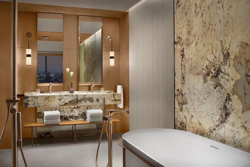 Luxuriöses Badezimmer mit Marmor, großzügiger Spiegel und eleganter Badewanne
