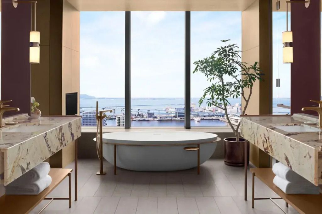 Luxuriöses Badezimmer mit freistehender Badewanne und atemberaubendem Blick auf die Bucht.