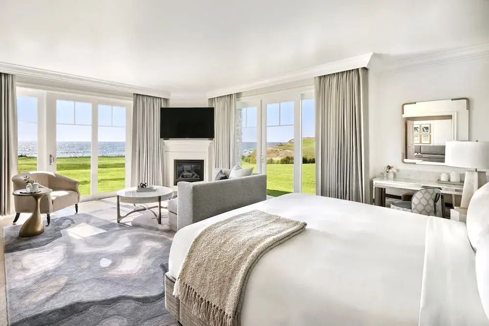 Luxuriöses Schlafzimmer mit Kamin und Panoramafenstern zum Meer