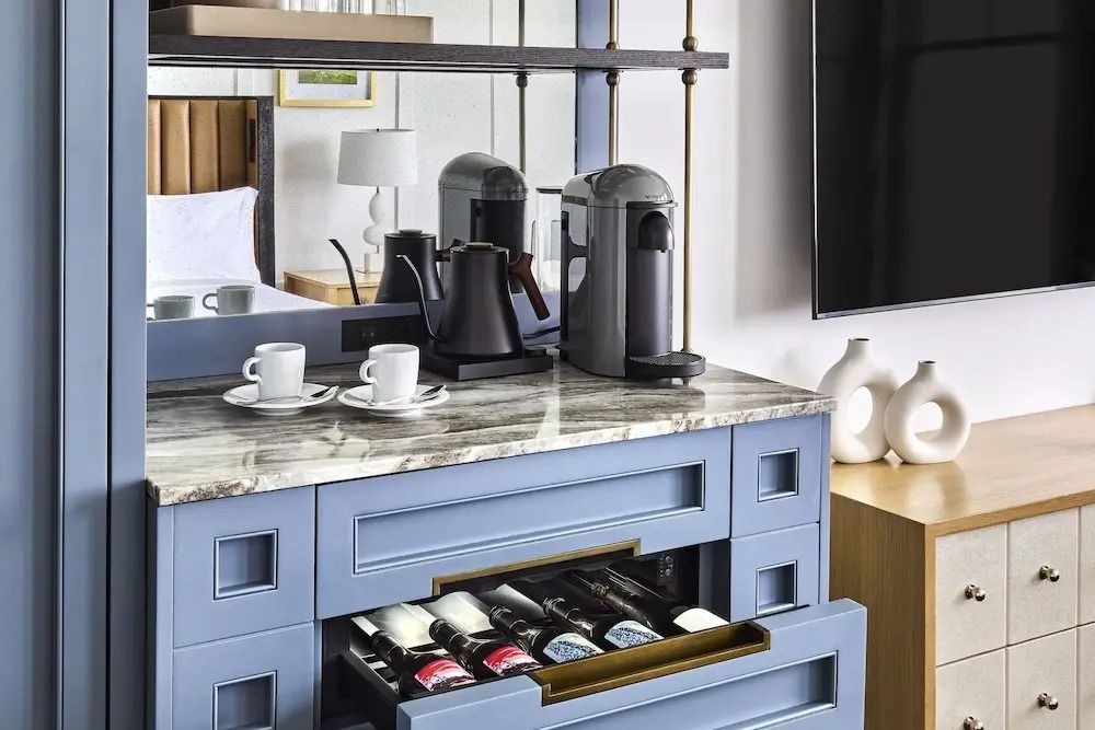 Marmorierte Anrichte mit Kaffeemaschine und Weinflasche im Zimmer