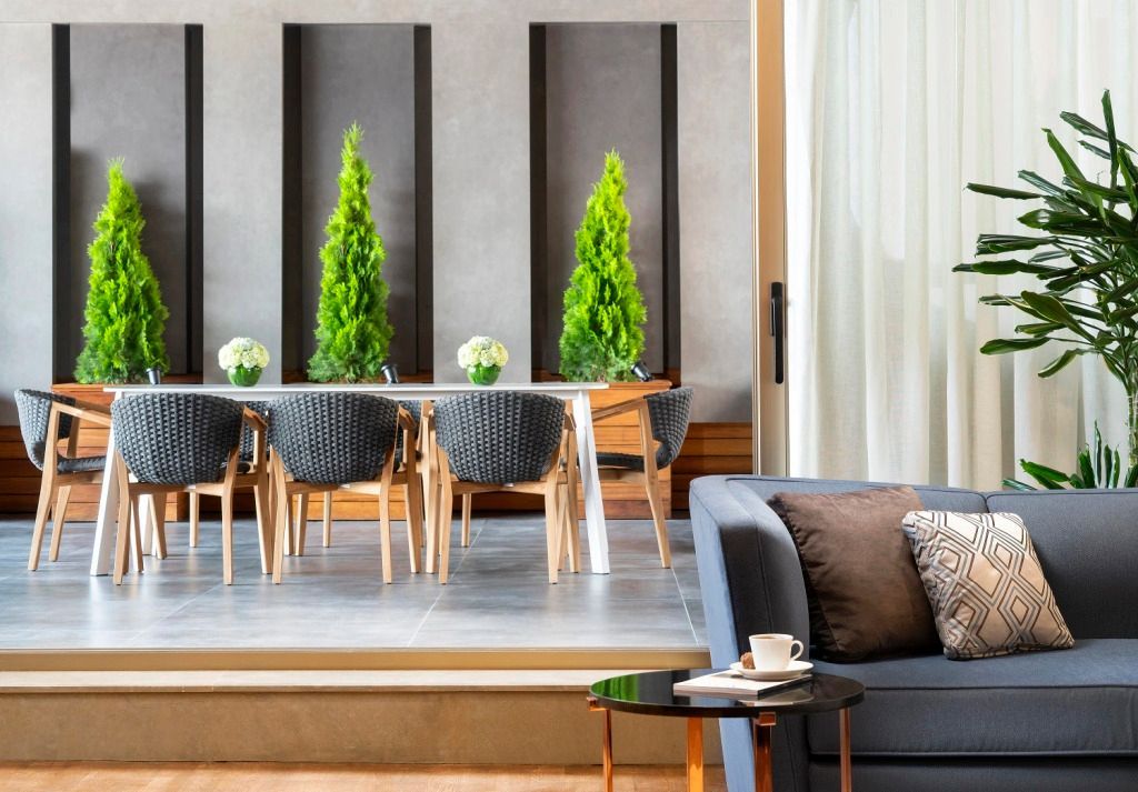 Stilvolle Lounge mit modernen Möbeln und Pflanzen nahe der Terrasse