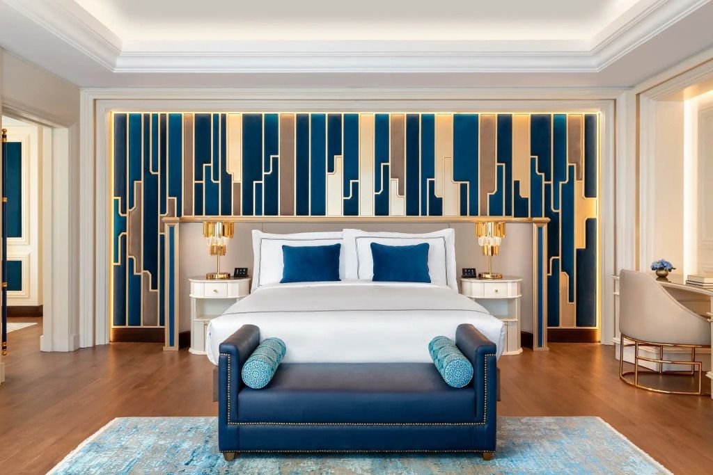 Luxuriöses Schlafzimmer mit stilvollem blauen Akzentkopfteil und eleganten Lampen