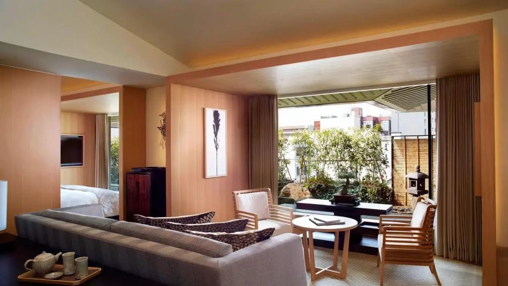 Helles Wohnzimmer mit eleganter Einrichtung und Blick auf Pflanzen im Ritz-Carlton Kyoto.